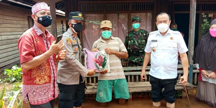 Kapolsek Danau Sembuluh Kawal Bupati Bagikan Bansos ke Warga