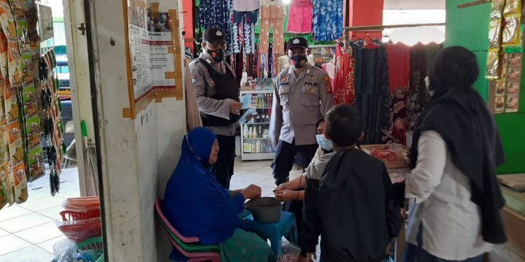 Personil Sat Binmas Sambil Membagikan Masker di Pasar Saik