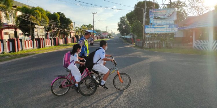 Sat Lantas Polres Seruyan Membantu Anak Sekolah Menyebrang Jalan