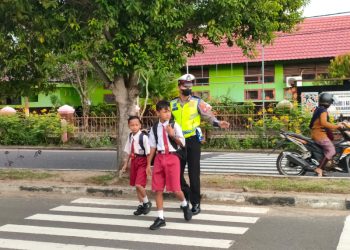 Sat Lantas Polres Seruyan Membantu Anak Sekolah Menyeberang Jalan