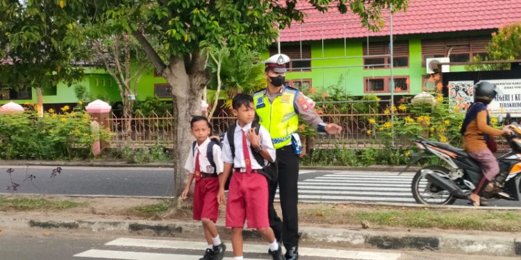 Sat Lantas Polres Seruyan Membantu Anak Sekolah Menyeberang Jalan